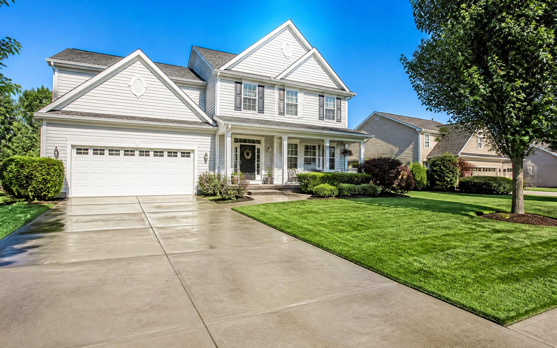 Beautiful suburban home with a freshly pressure washed driveway on a sunny morning